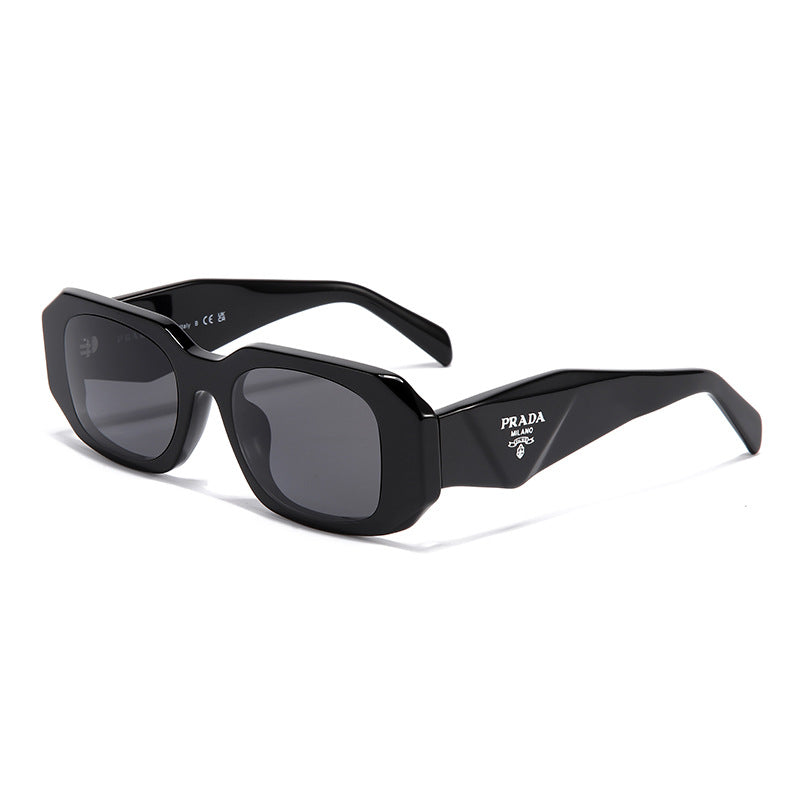 Black square frame sunglasses with grey lenses and white Prada logo on temple. UV400 protection for driving.