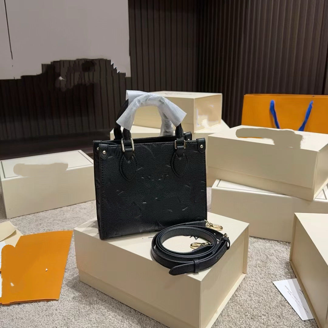 Black premium woman's tote large capacity bag with detachable shoulder strap and gold hardware on cream packaging