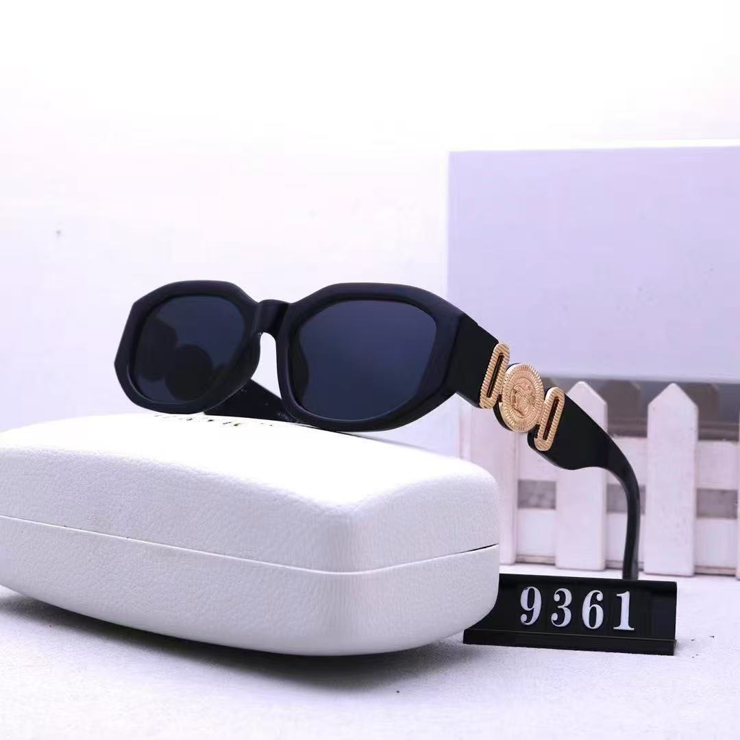 Black box frame sunglasses with gold temple emblem and UV protection lenses resting on a white case.