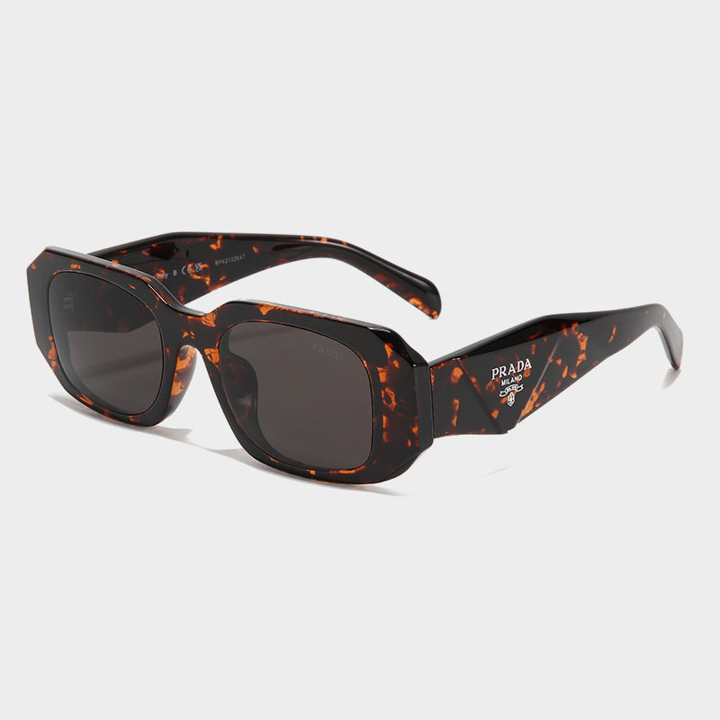 Tortoise square frame sunglasses with dark lenses and Prada logo on temple for driving and UV protection.