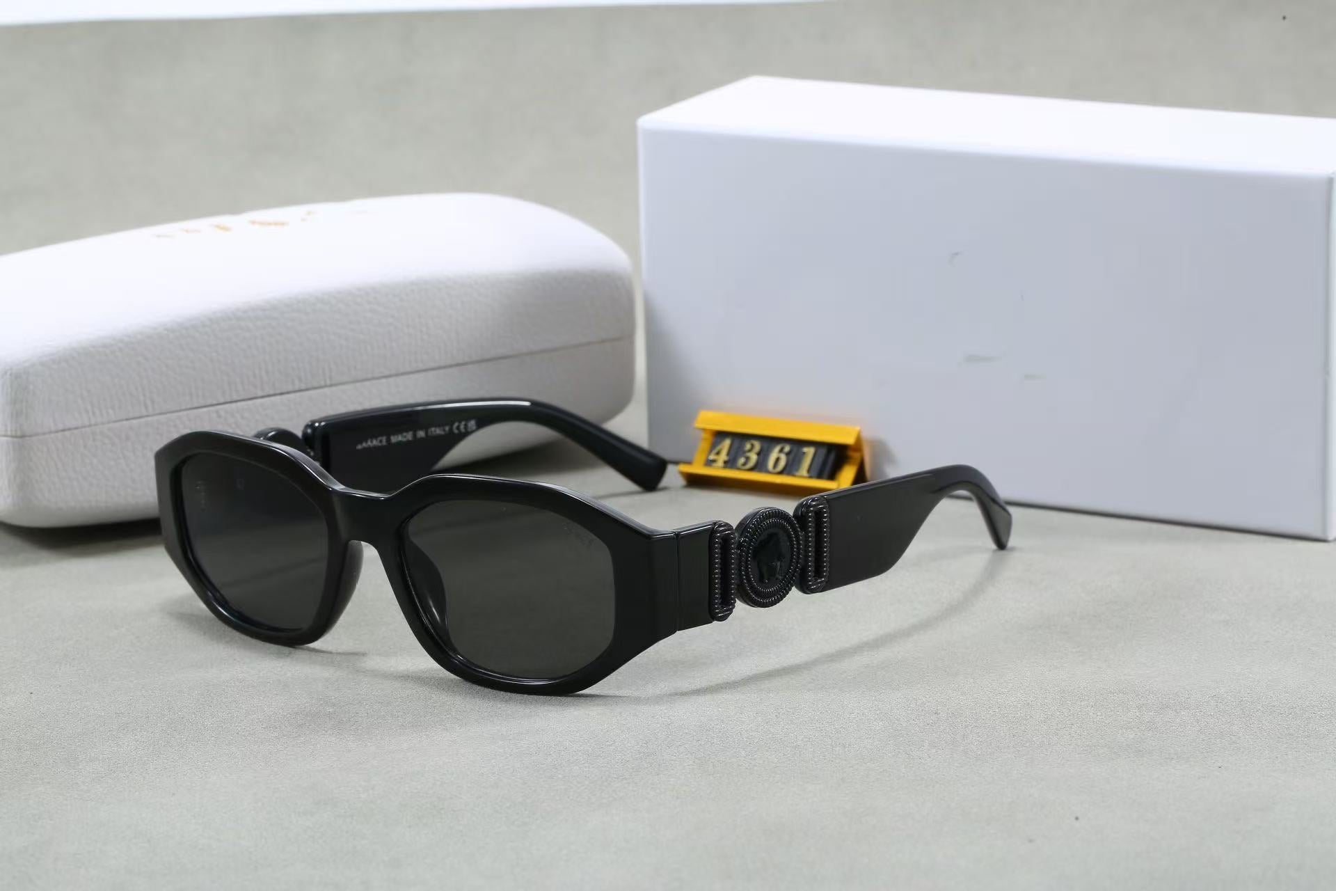Black box frame sunglasses with metallic temple emblem and UV protection lenses, shown with white case and box.