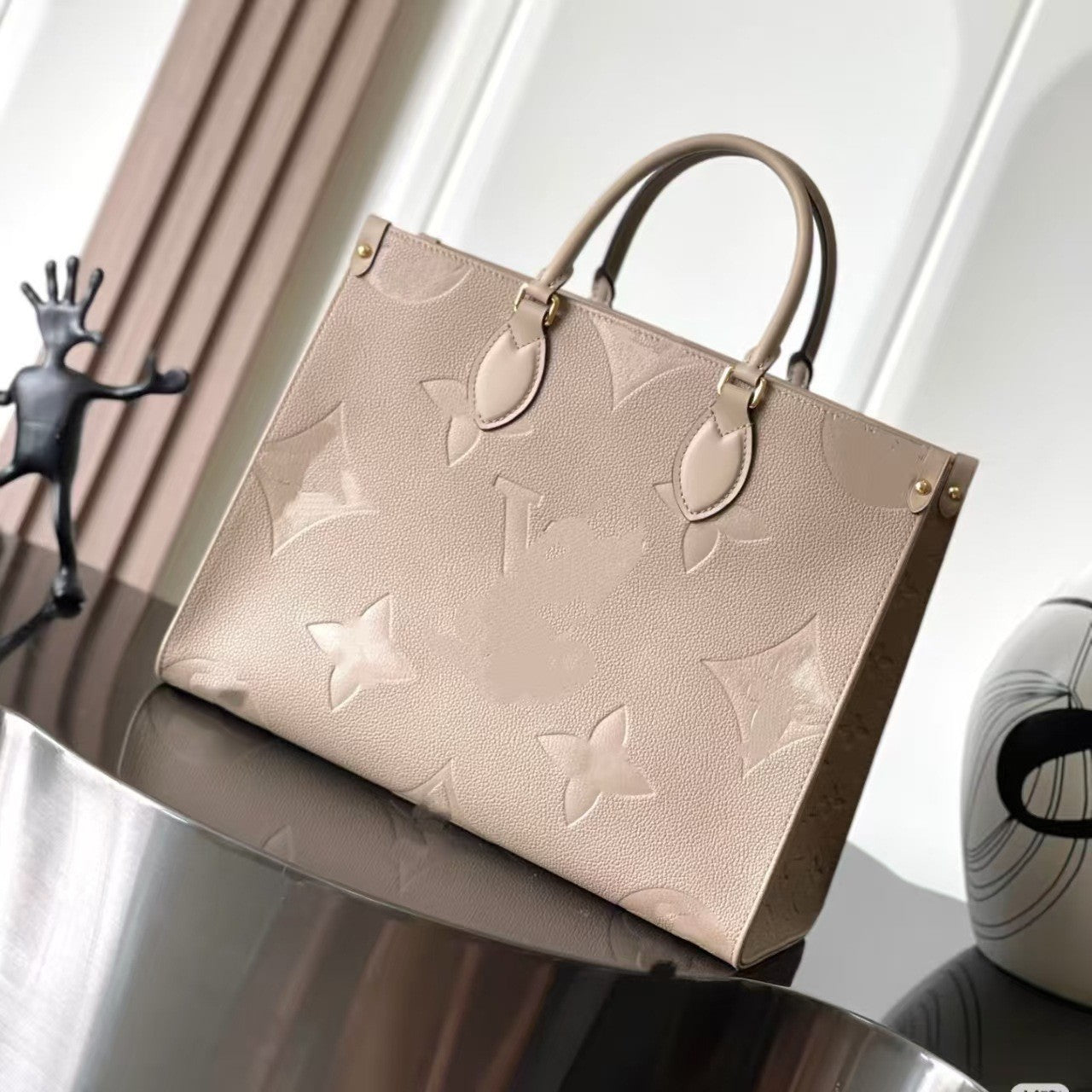 Cream leather shoulder tote with embossed floral pattern and gold hardware