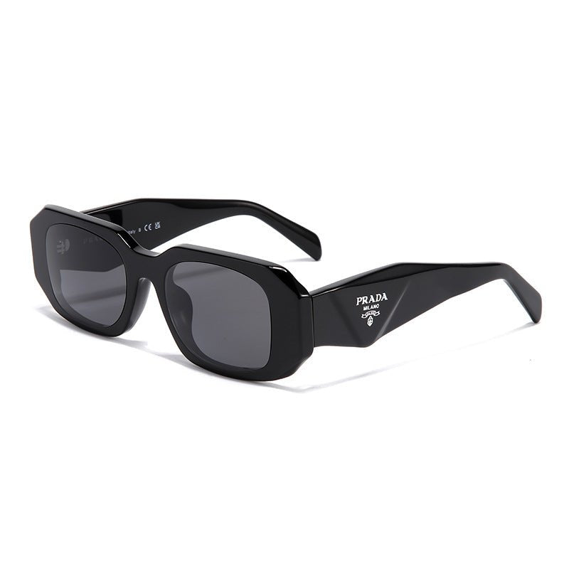 Black square frame sunglasses with grey lenses and white Prada logo on temple. UV400 protection for driving.
