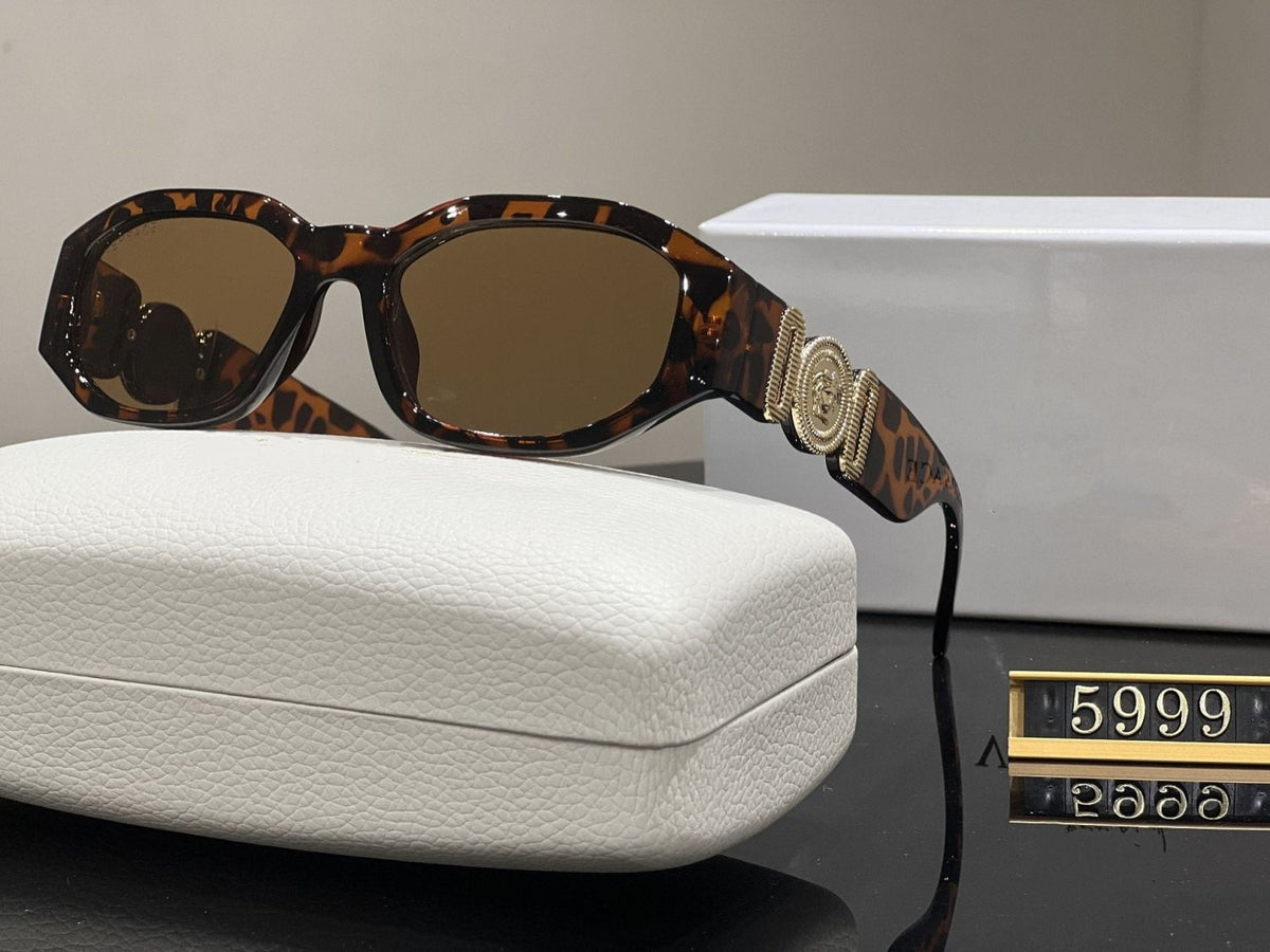 Tortoise box frame sunglasses with gold metallic temple emblem and UV protection lenses resting on a white case.