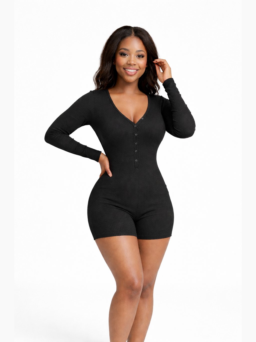 African American woman in black sculpted jumpsuit posing confidently indoors, highlighting the flattering fit and elegant design.