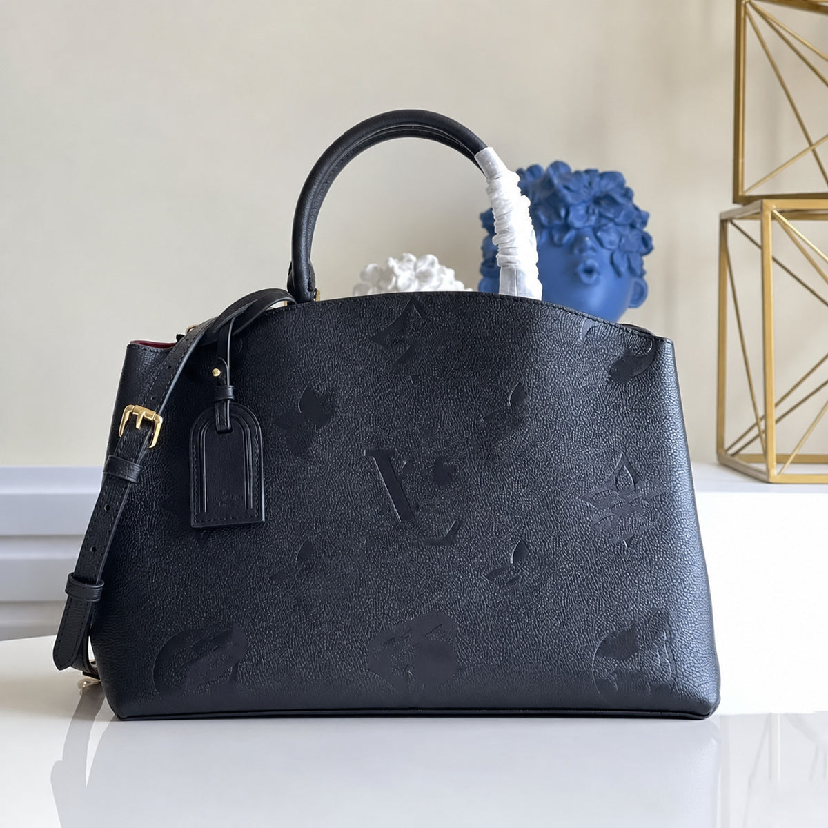 The Urban Montaigne Signature Luxe handbag in black leather with embossed monogram design and gold hardware.